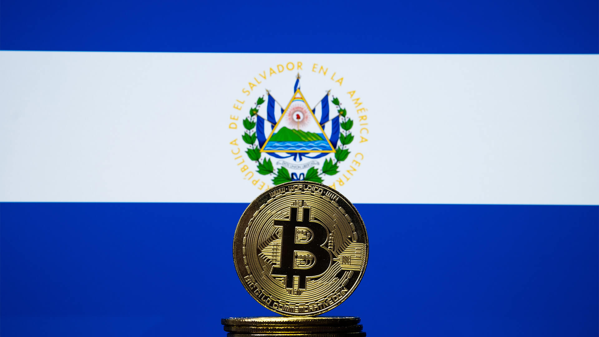 Bitcoins stacked in front of the El Salvador flag