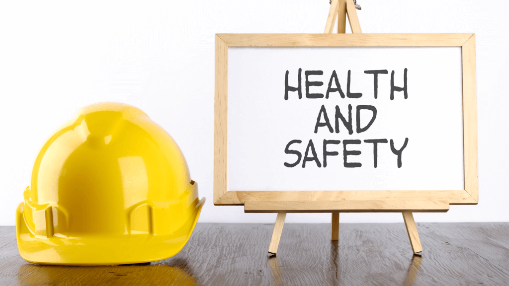 Safety helmet and white board with words Health and Safety